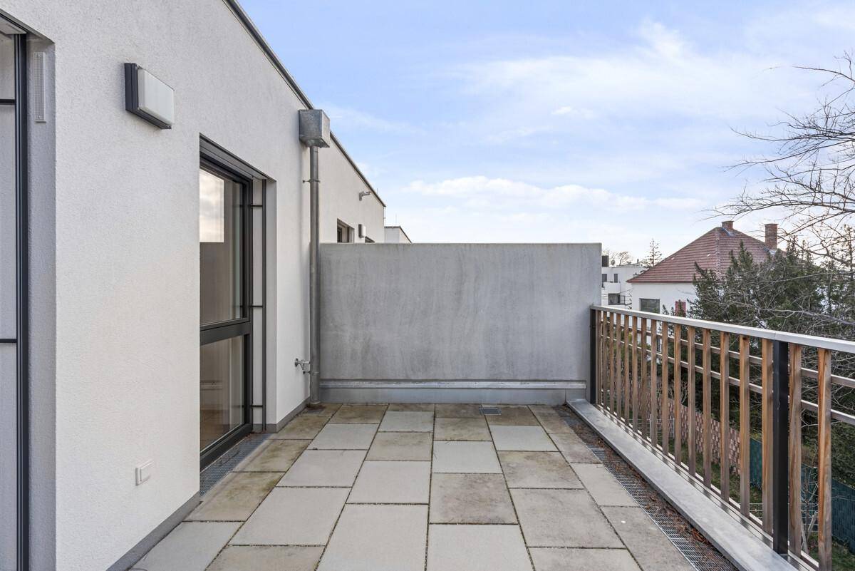 Geräumiger Balkon mit Fliesenboden und Metallgeländer, bietet weite Aussicht.