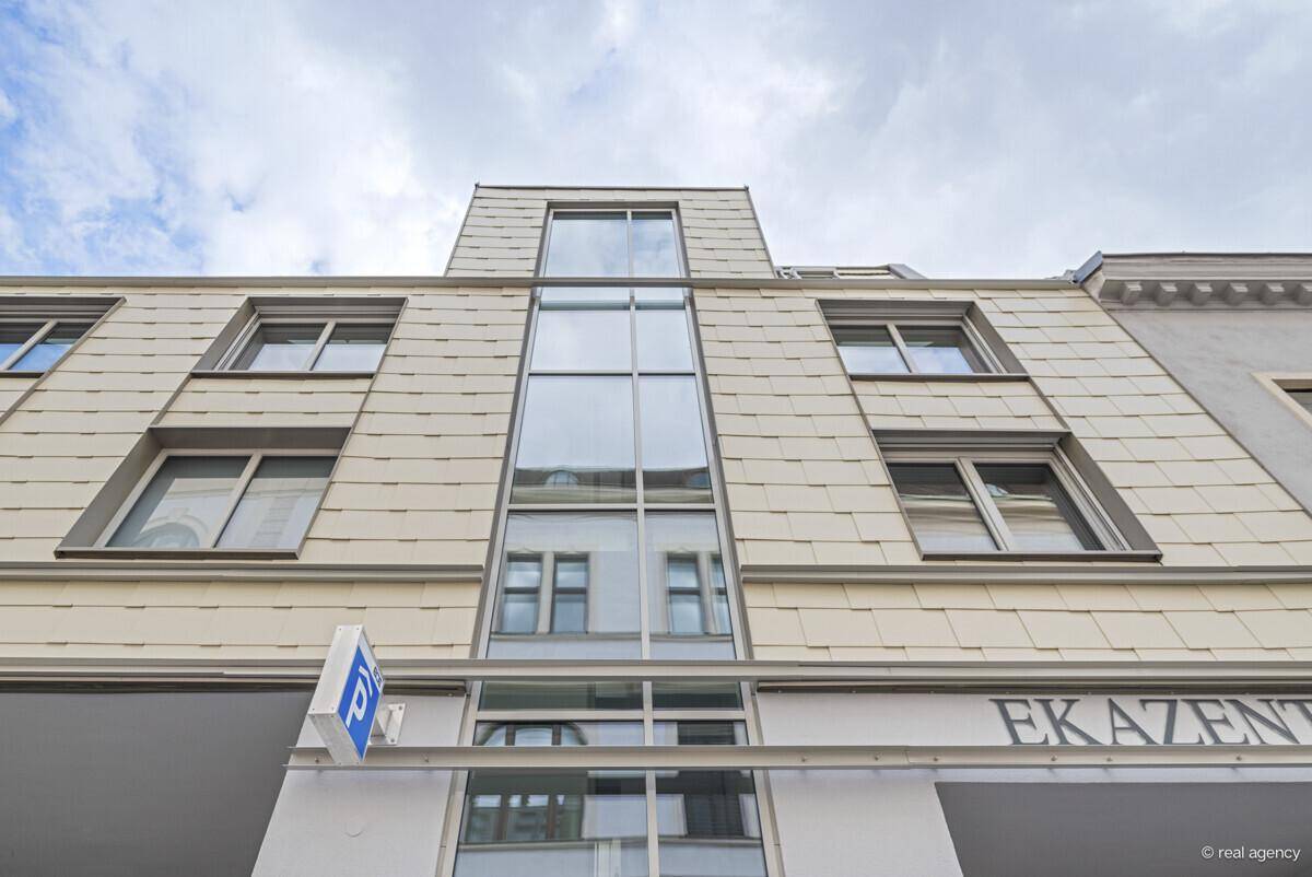 Moderne Fassade eines Gebäudes mit großen Fenstern und vertikaler Glasfront.