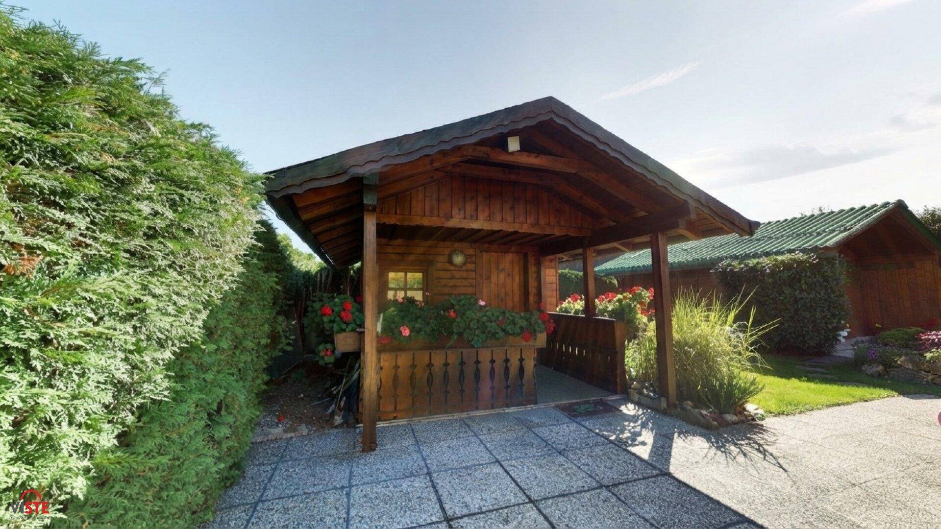 Rustikales Holzhaus mit überdachtem Eingangsbereich und Blumenkästen.