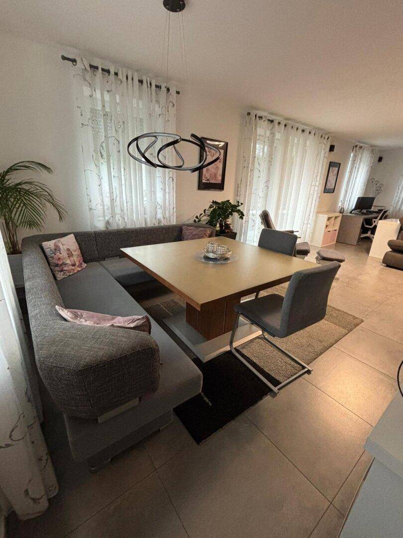 Gemütlicher Essbereich mit Eckbank, großem Tisch und moderner Pendelleuchte.