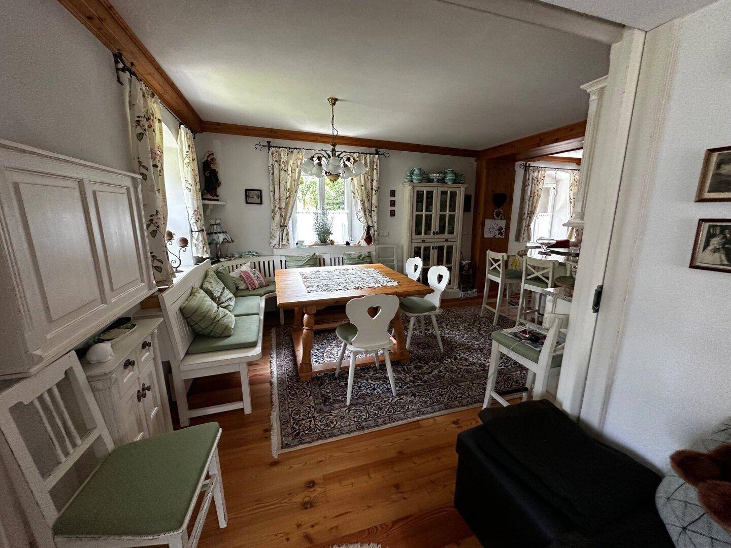 Geräumiger Essbereich mit Holztisch, Sitzbank und traditionellen Möbeln, mit Holzboden.