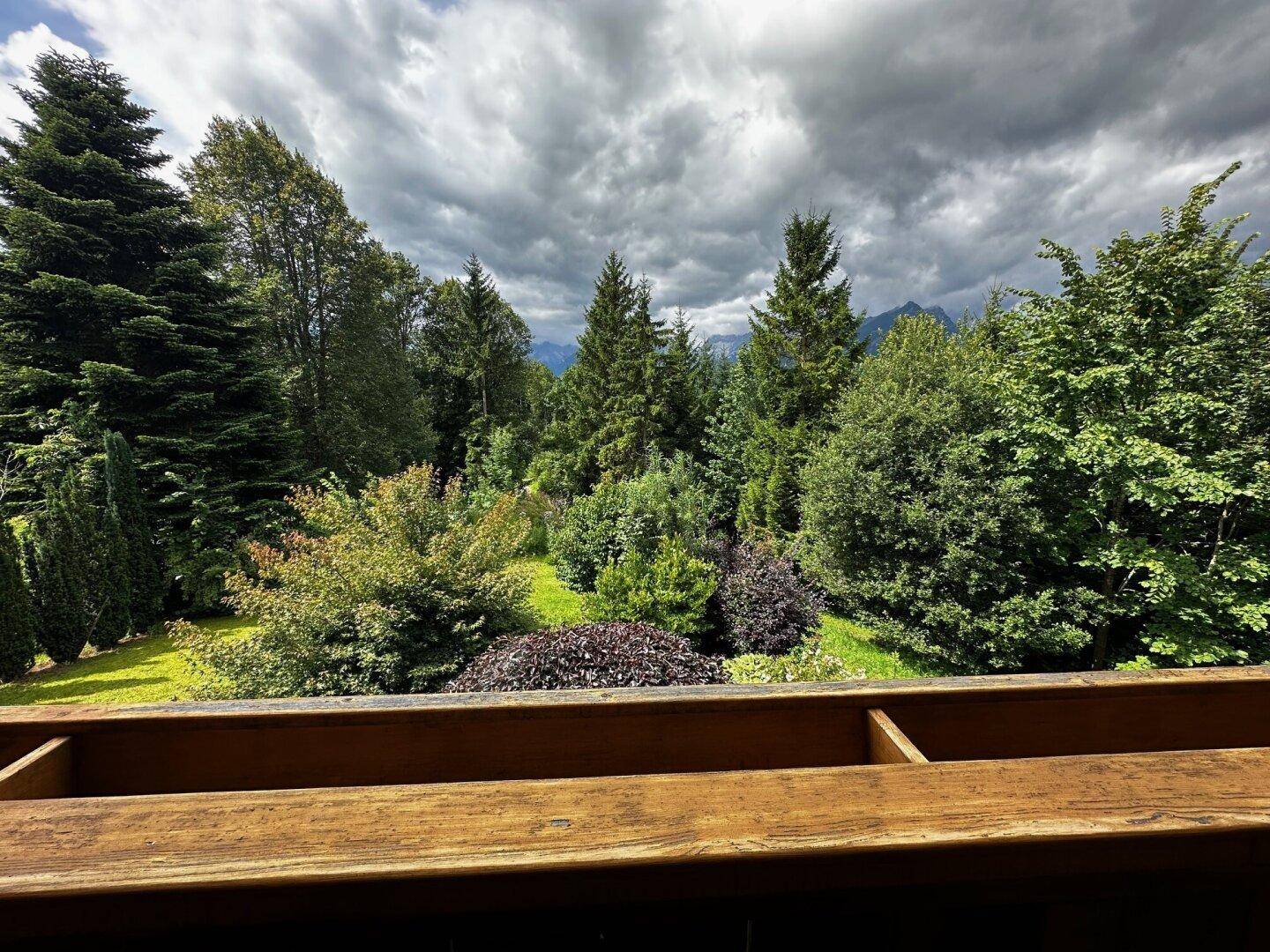Weitläufiger Blick auf grüne Wälder und Berge von einem erhöhten Standpunkt.