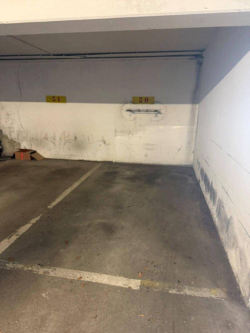 Tiefgaragenstellplatz mit Betonwänden und markierten Parkflächen für Fahrzeuge.