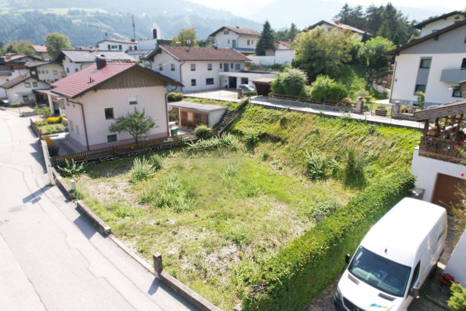 Übersicht des Baugrundstücks mit angrenzenden Wohnhäusern und grüner Umgebung.