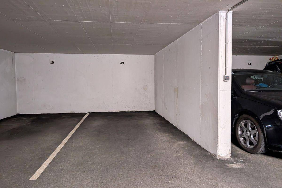 Leerer Tiefgaragenstellplatz mit Betonwänden und -decke, bereit zur Nutzung für ein Fahrzeug.