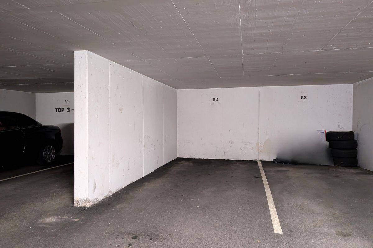 Geräumiger Tiefgaragenstellplatz mit Betonwänden und -decke, bietet Platz für ein Fahrzeug.