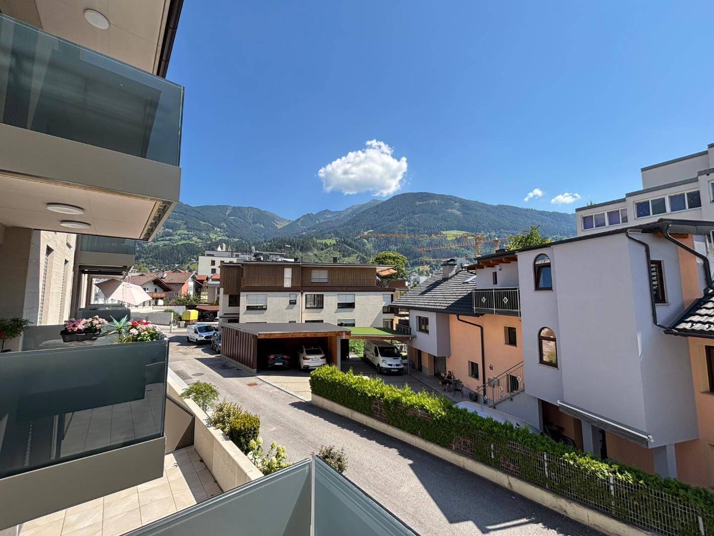 Sonniger Balkon mit weitem Blick auf die Berge und die umliegende Wohngegend.