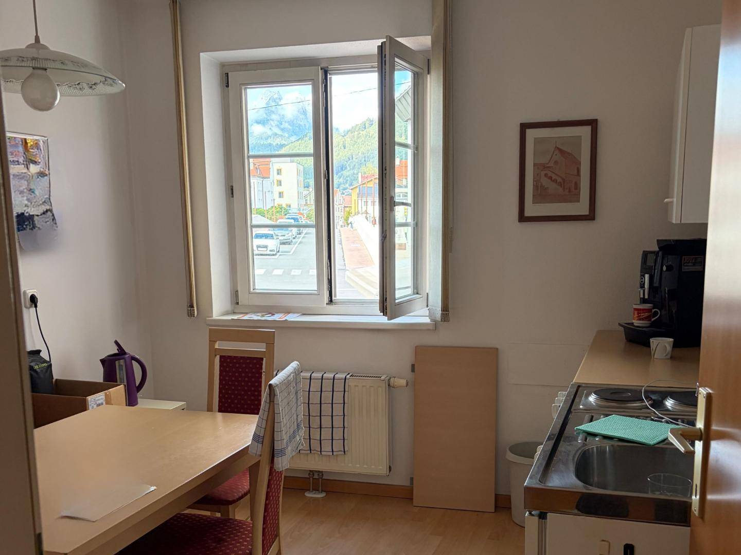 Kleine Küche mit Fenster, einfacher Ausstattung und Blick auf die Straße.