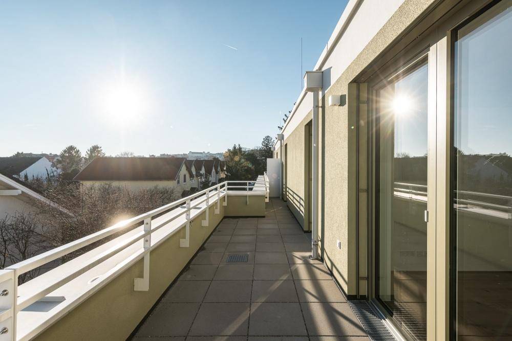 Sonnige Dachterrasse mit weitem Blick über die Umgebung und viel natürlichem Licht.
