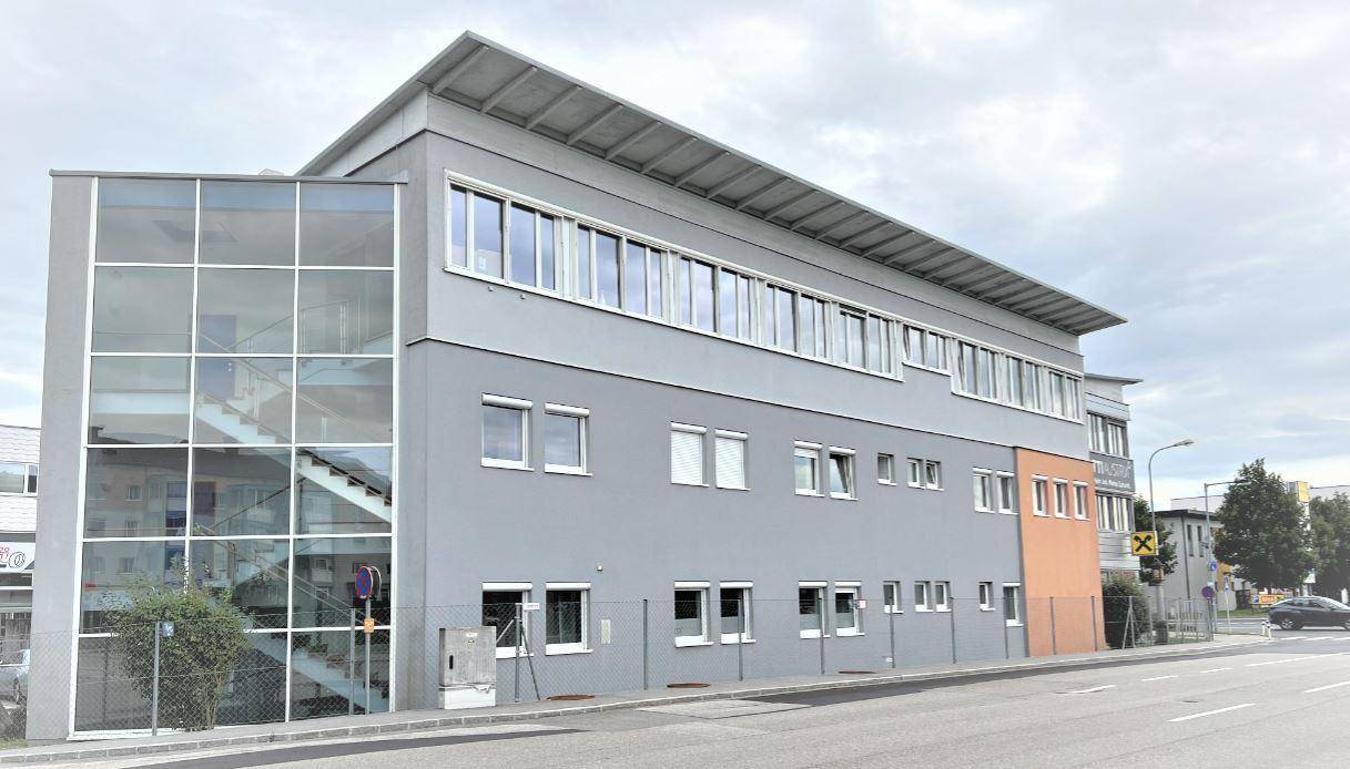 Moderne Architektur des Geschäftsgebäudes mit großer Glasfassade und Blick auf die Straße.