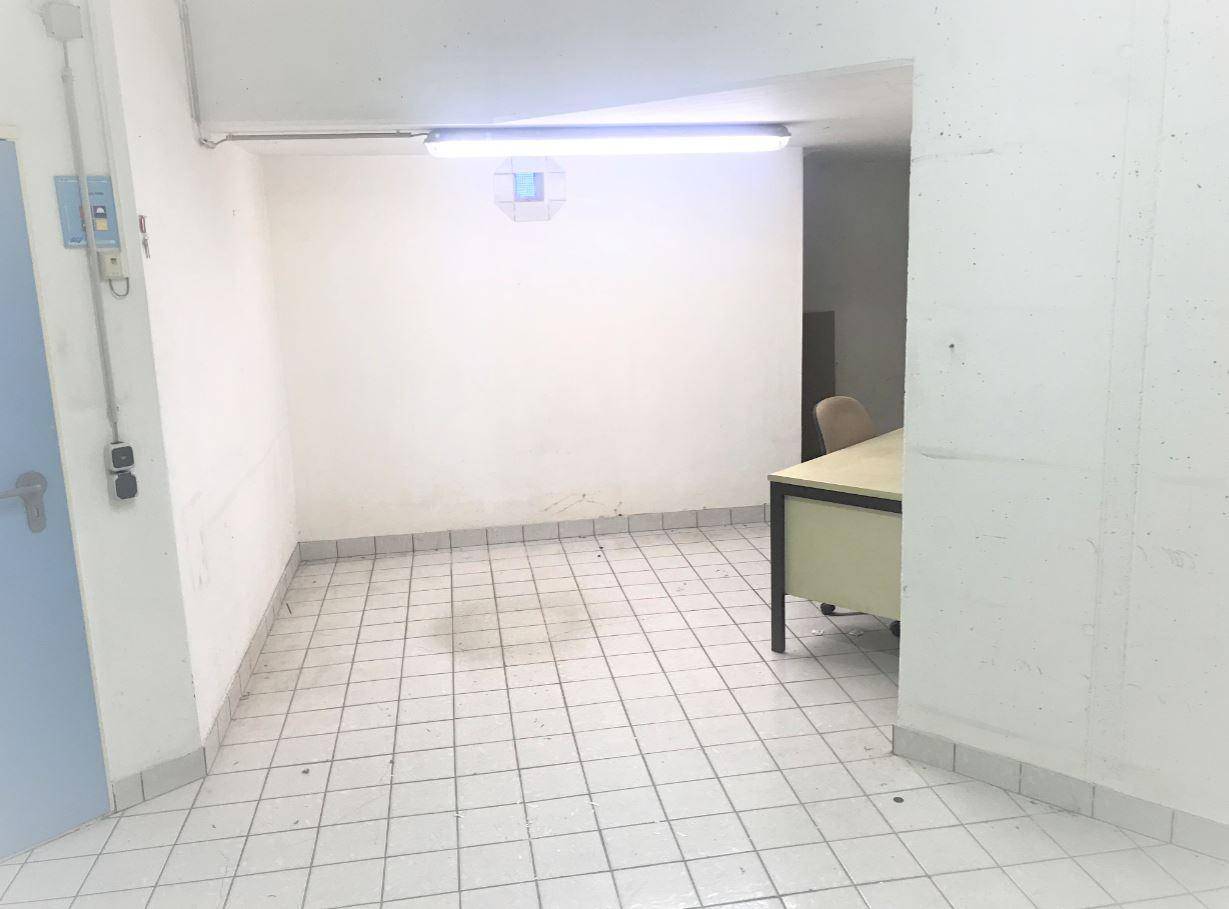 Geräumiger Lagerraum im Untergeschoss mit Fliesenboden und einfacher Beleuchtung.