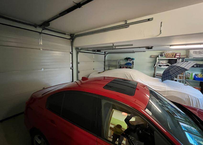 Geräumige Garage mit zwei Stellplätzen und Stauraum an den Wänden.
