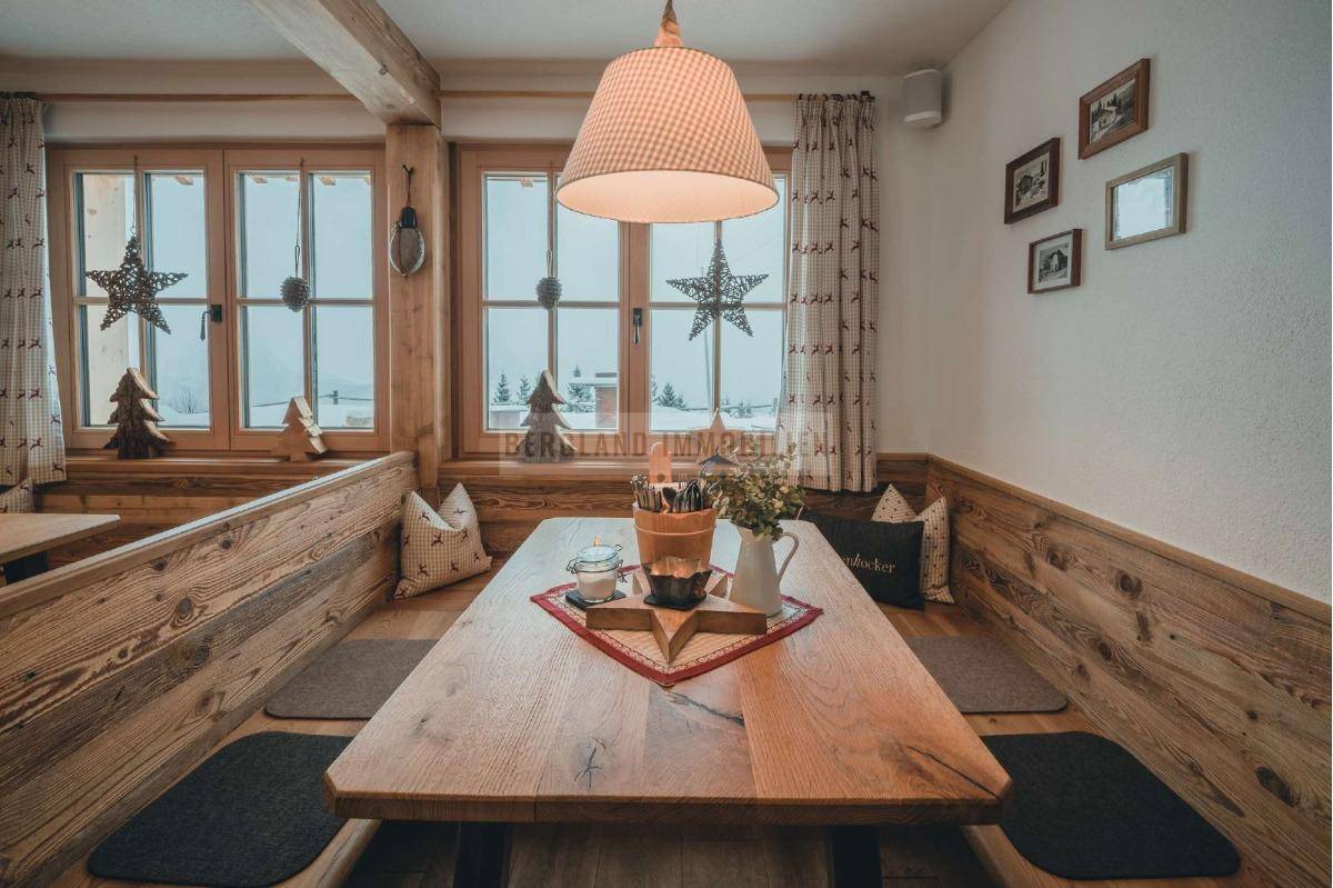 Einladender Essbereich mit traditionellen Holzmöbeln und festlicher Dekoration, hell durch große Fenster.