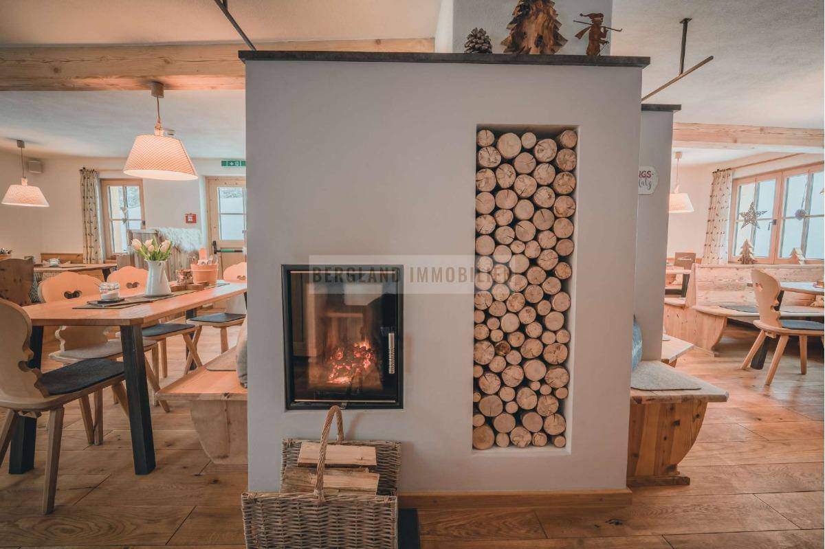 Moderner Kamin mit Holzscheitlagerung, schafft eine warme und einladende Atmosphäre im Essbereich.
