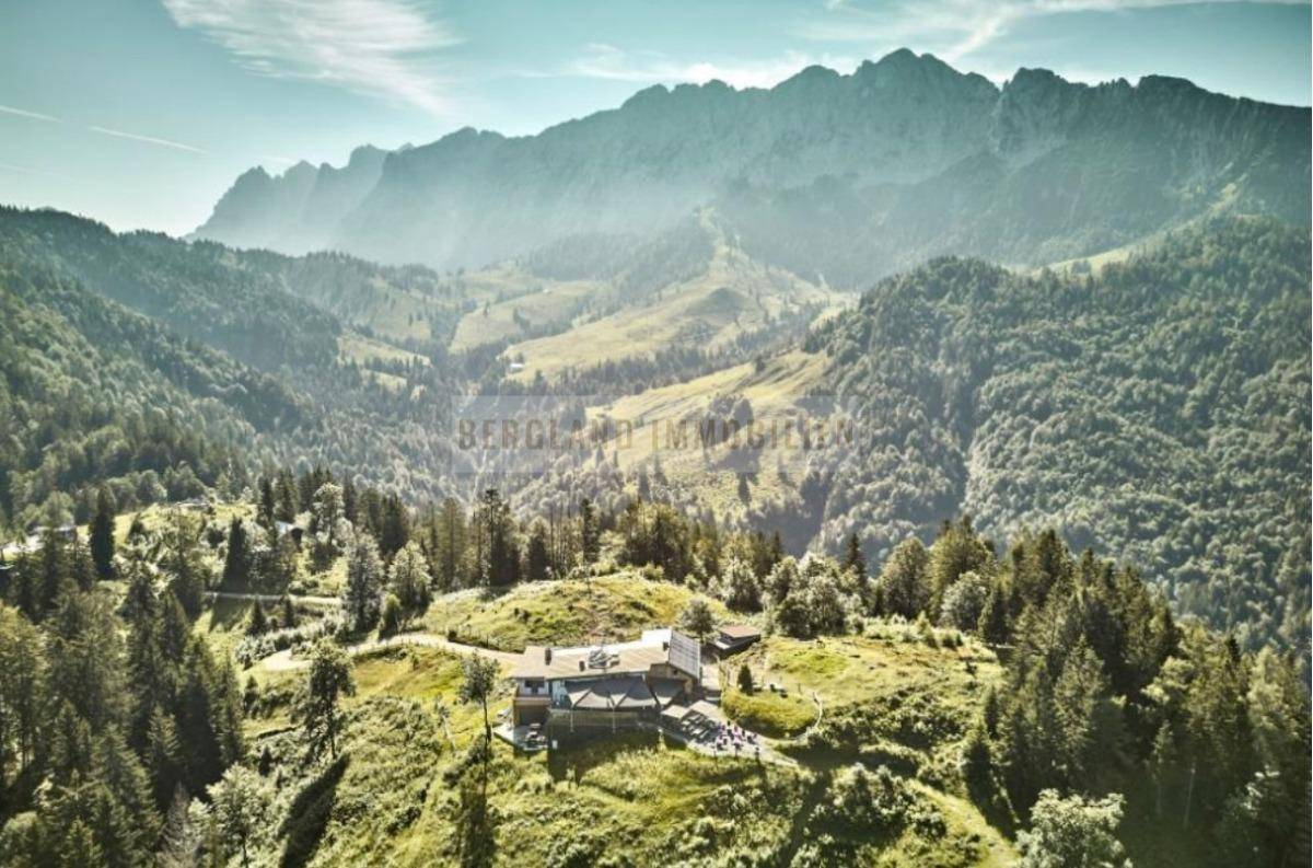 Weitläufige Luftaufnahme des Anwesens, eingebettet in eine malerische Berglandschaft mit dichten Wäldern.
