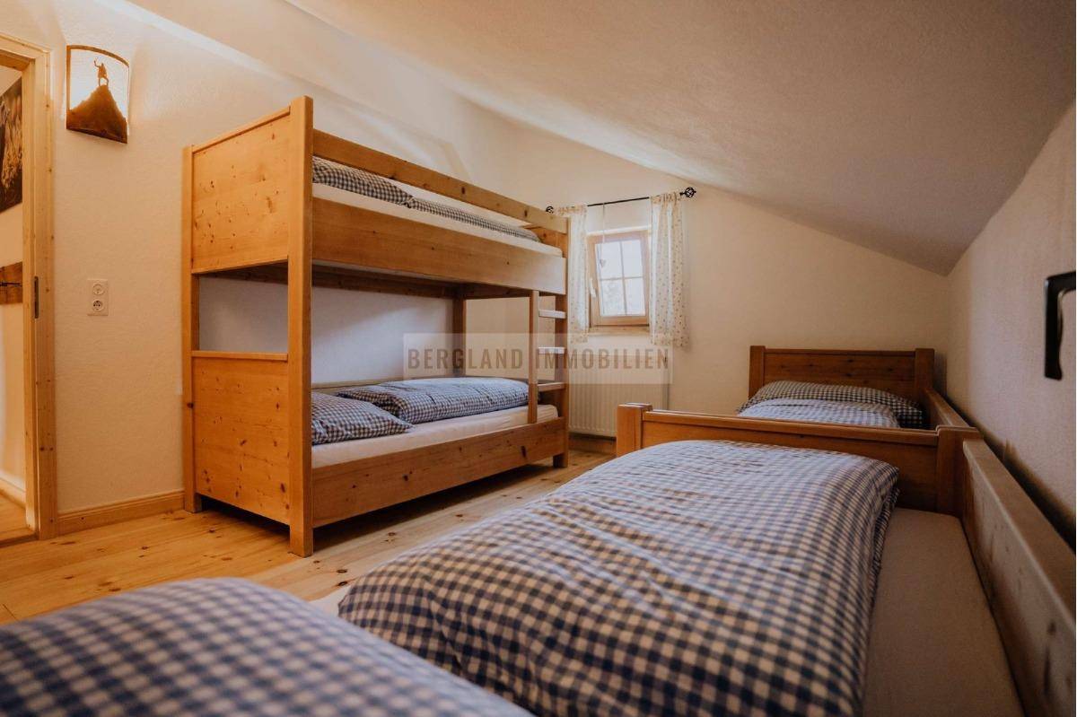 Geräumiges Schlafzimmer mit Etagenbett und Einzelbetten, ideal für Familien oder Gruppen.