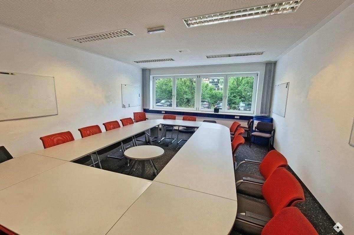 Grundriss des Erdgeschosses mit großem Hallenbereich und angrenzenden Büroräumen.