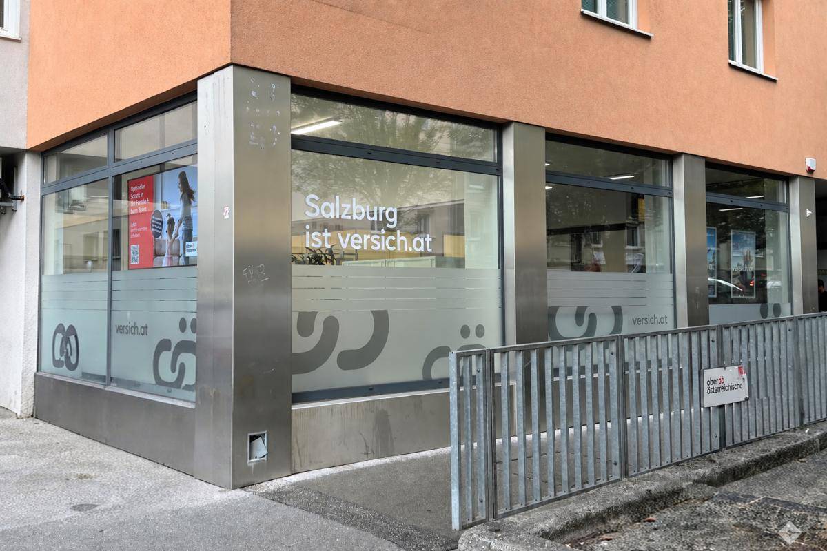 Außenansicht eines Geschäftsgebäudes mit großen Fenstern und einer Rampe für Barrierefreiheit.