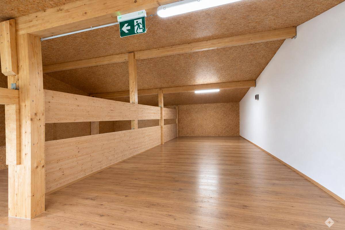 Helle Empore mit Holzboden und Holzgeländer, bietet zusätzlichen Raum über dem Lagerbereich.