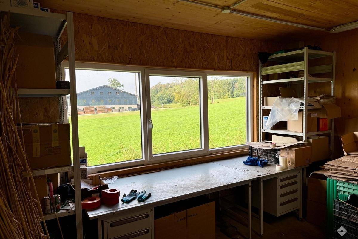 Werkstatt oder Arbeitsraum mit großem Fenster und Blick auf die grüne Landschaft.