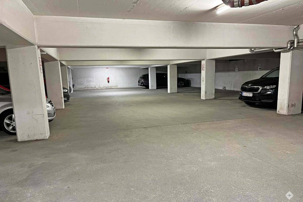 Tiefgarage mit Betonpfeilern und mehreren geparkten Fahrzeugen.