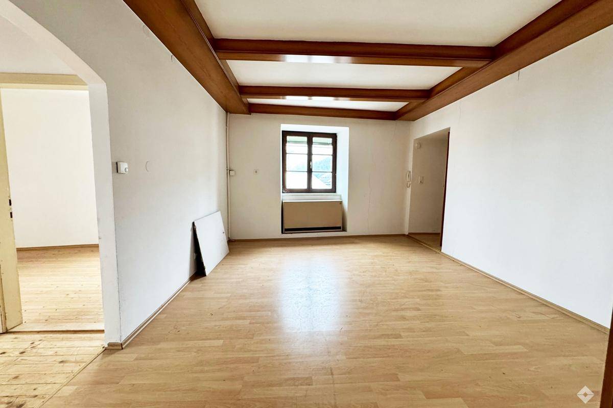 Geräumiger Raum mit Holzbalkendecke und Laminatboden, bereit für individuelle Gestaltung.
