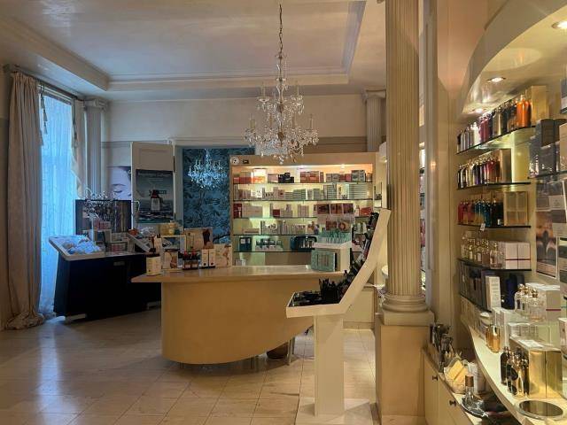 Luxuriöser Behandlungsraum mit goldener Tapete, dunklem Holzboden und professioneller Ausstattung für Wellness.