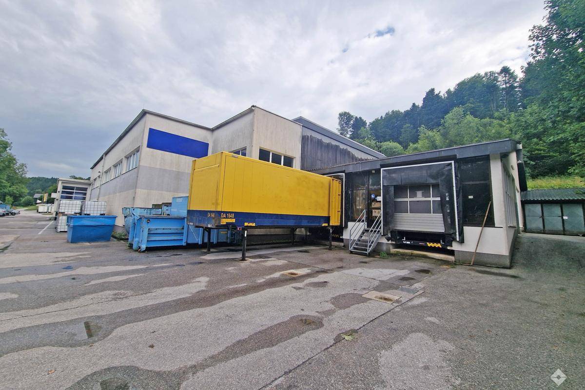 Geräumige Lagerhalle mit hohen Decken, Metallregalen und einem Gabelstapler für effiziente Logistik.