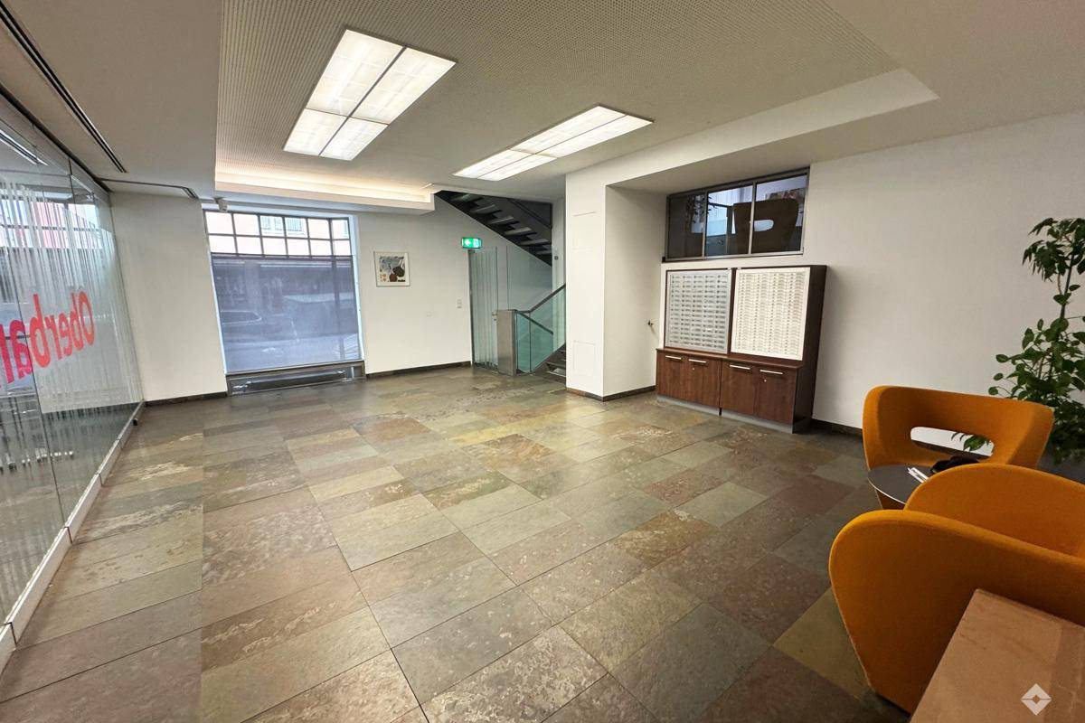 Privates Büro mit großem Schreibtisch, Holzschränken, Teppichboden und Klimaanlage für angenehmes Arbeiten.