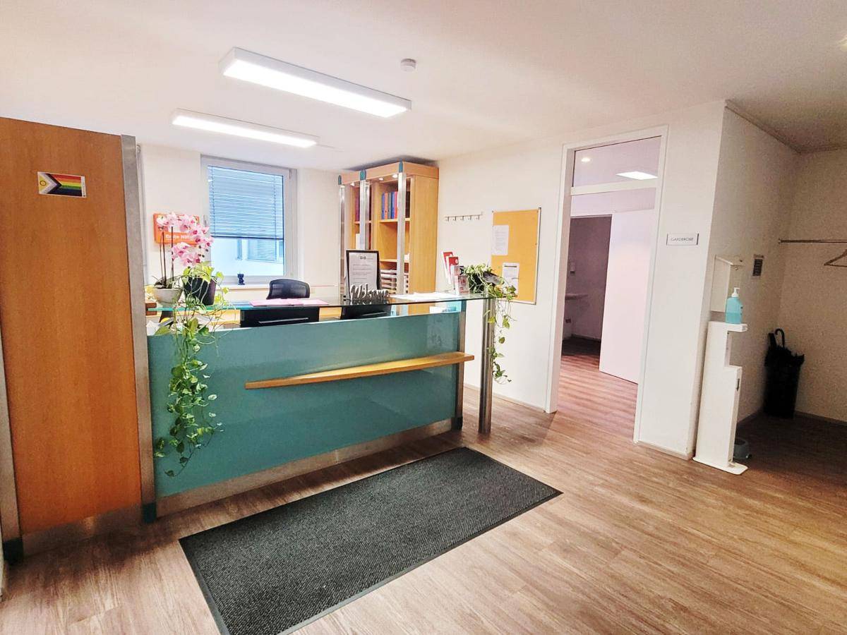 Helles Büro mit großen Fenstern, integrierten Holzregalen und einem funktionalen Arbeitsplatz.