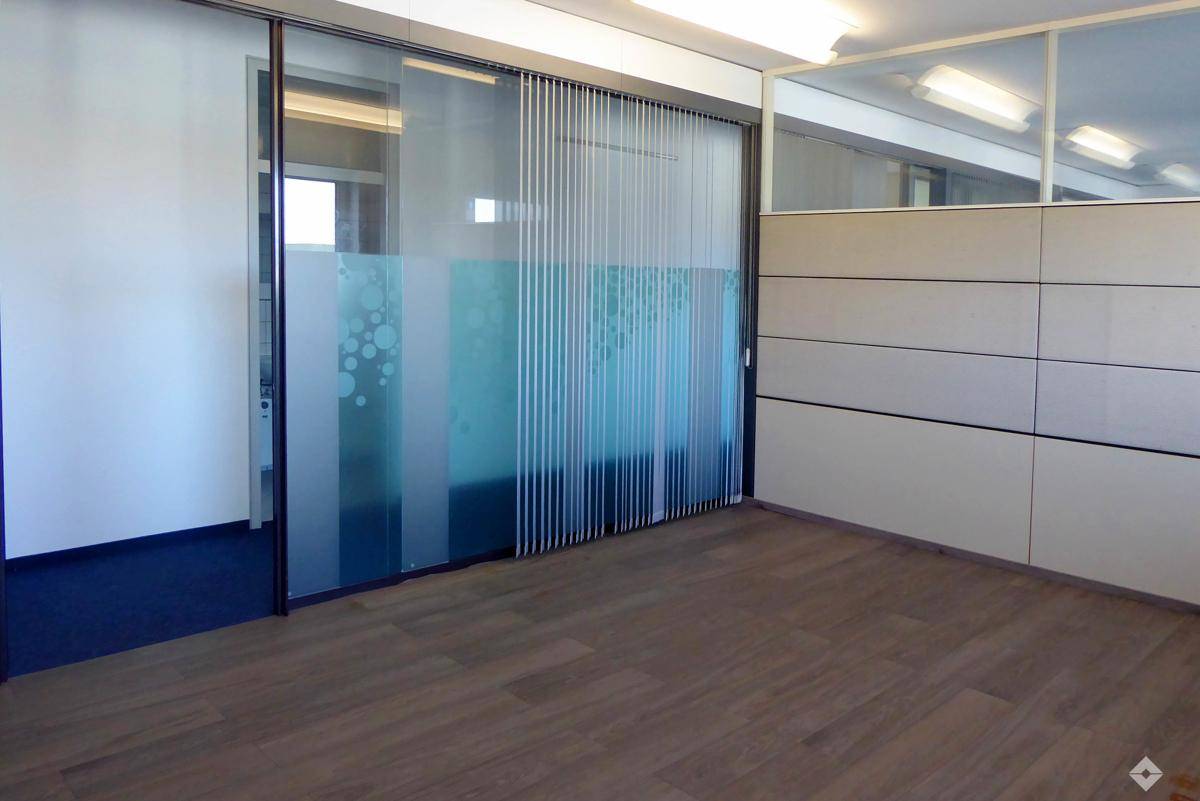 Moderner Bürobereich mit Holzfußboden und satinierten Glastrennwänden für mehr Privatsphäre.