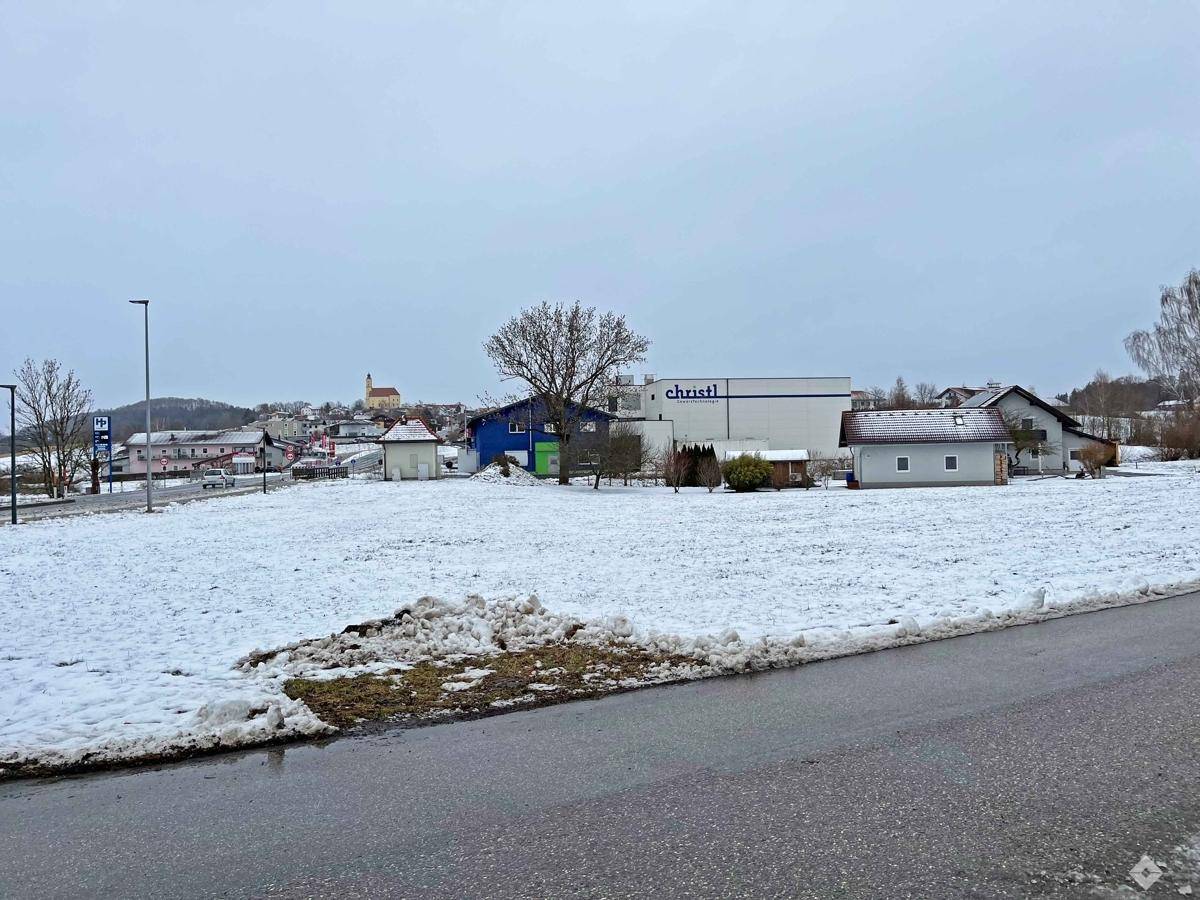Weitläufiges, schneebedecktes Grundstück mit Blick auf die umliegende Bebauung und eine entfernte Kirche.