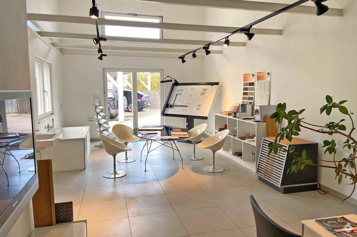 Heller, moderner Büroraum oder Ausstellungsbereich mit weißen Wänden, Fliesenboden und Designermöbeln.