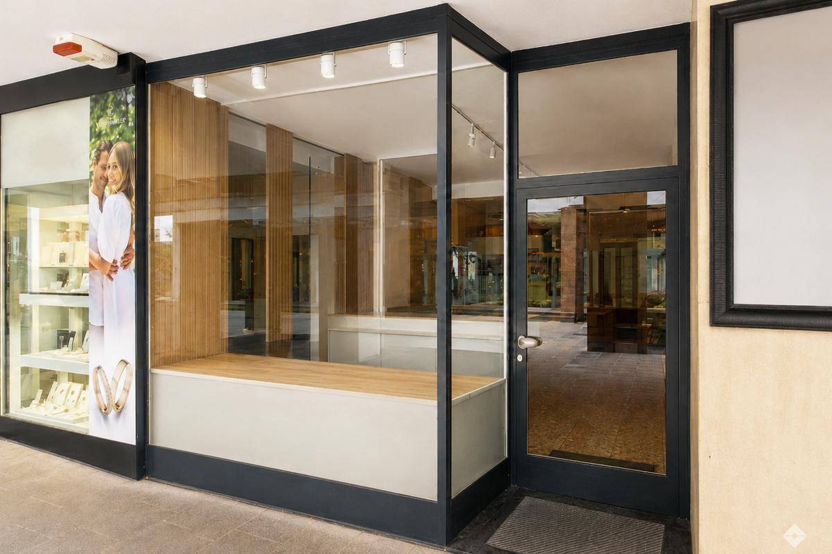 Moderne Ladenfront mit großen Glasfenstern und schwarzem Rahmen, ideal für Einzelhandel oder Büro.