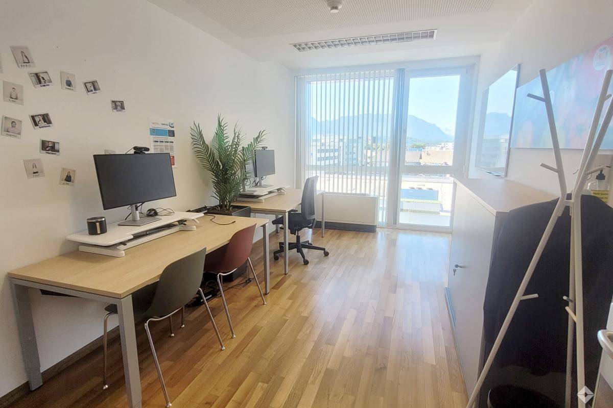 Geräumiges und helles Büro mit mehreren Arbeitsplätzen und Panoramablick auf die Berge.