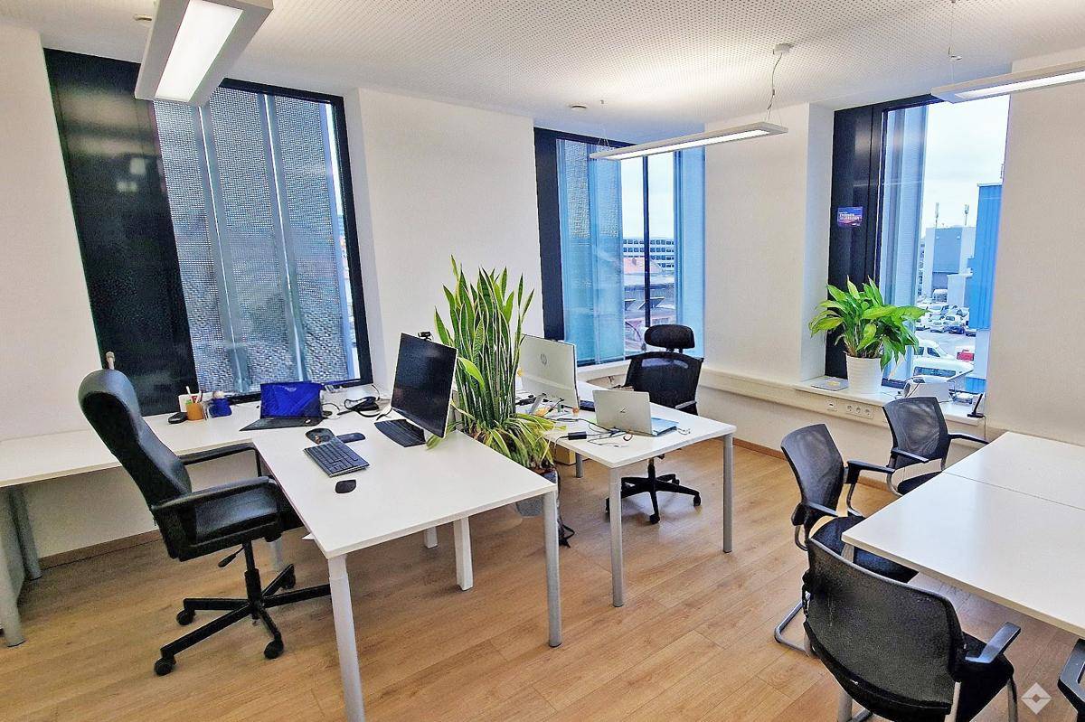 Helles und geräumiges Büro mit mehreren Arbeitsplätzen und moderner Einrichtung.