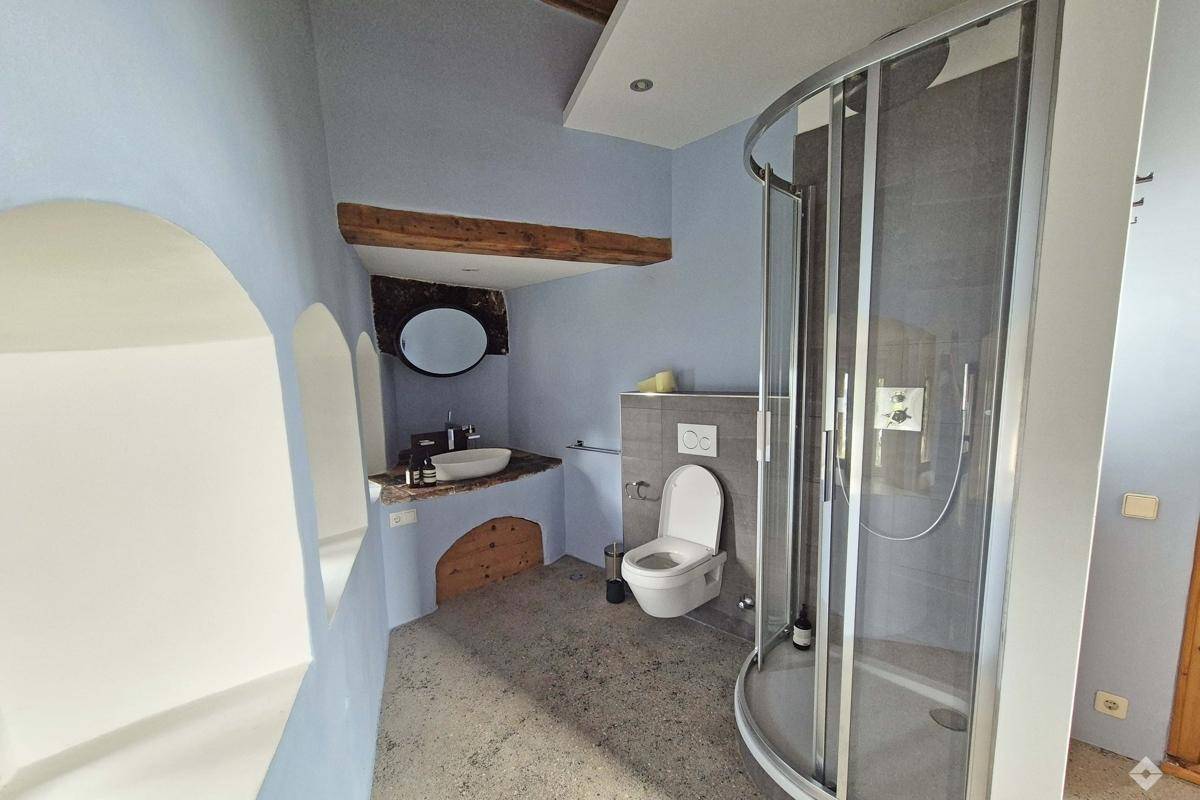 Modernes Badezimmer mit Dusche, Waschbecken, Toilette und blauen Wänden.