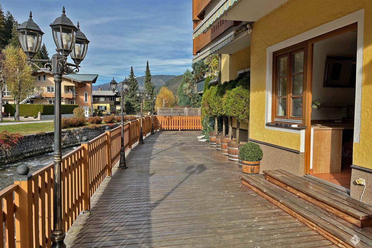 Geräumige Holzterrasse am Flussufer mit traditionellen Laternen und Blick auf die Umgebung.