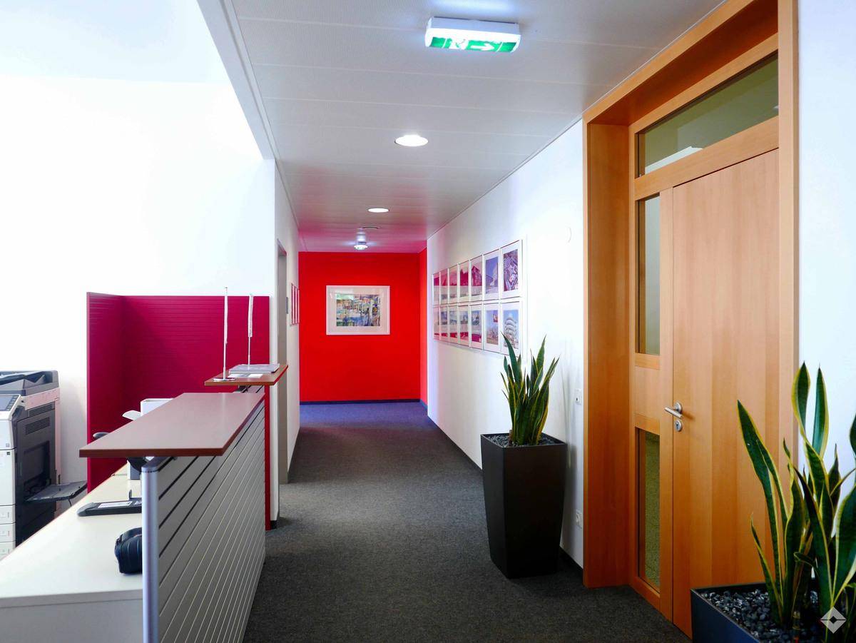Modernes Büro mit großen Fenstern, viel Tageslicht und einem funktionalen Arbeitsplatz.