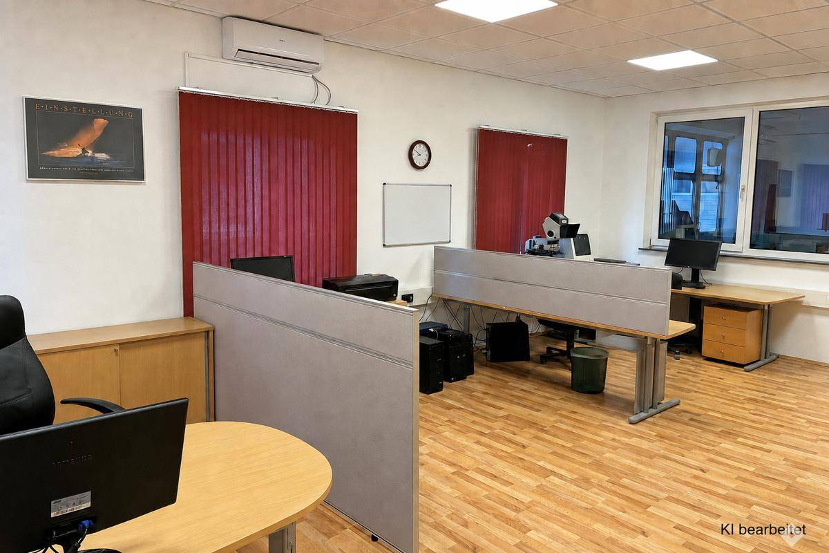 Helles Büro mit mehreren Arbeitsplätzen, Laminatboden und roten Fensterjalousien.