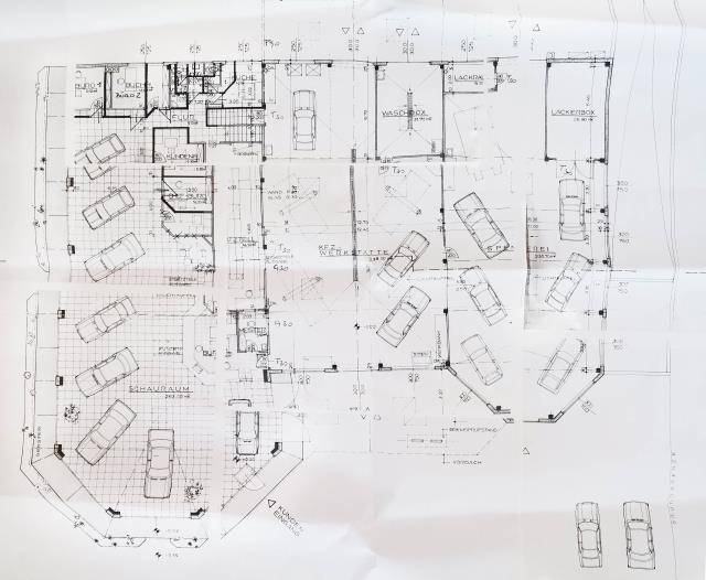 Grundrissplan eines Erdgeschosses mit verschiedenen Räumen und eingezeichneten Parkplätzen.