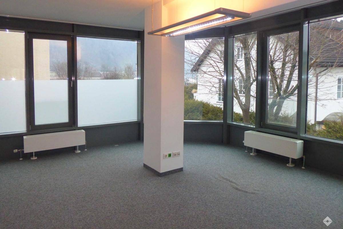 Großes, offenes Büro mit modernen Glasabtrennungen und Teppichboden, bereit zur Einrichtung.