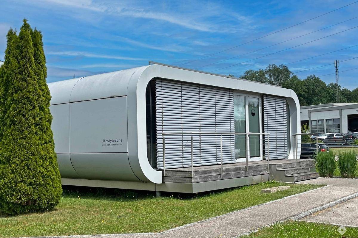 Vorderansicht der modernen modularen Einheit mit Jalousien an den Fenstern und einer kleinen Holzplattform.