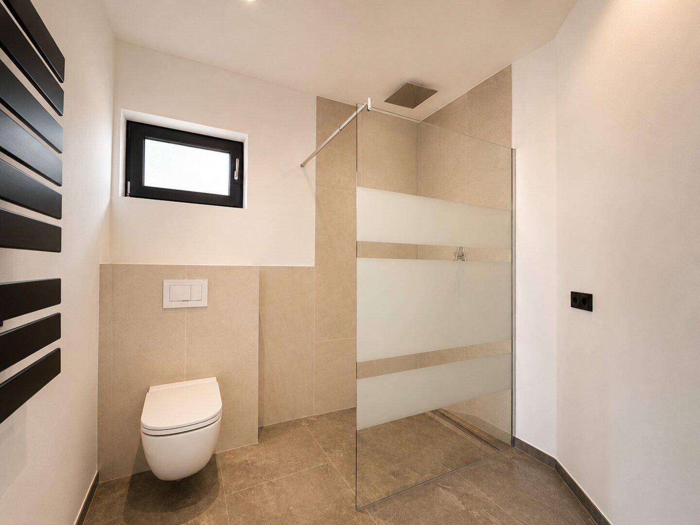Modernes Badezimmer mit begehbarer Dusche, Wand-WC und Fenster.