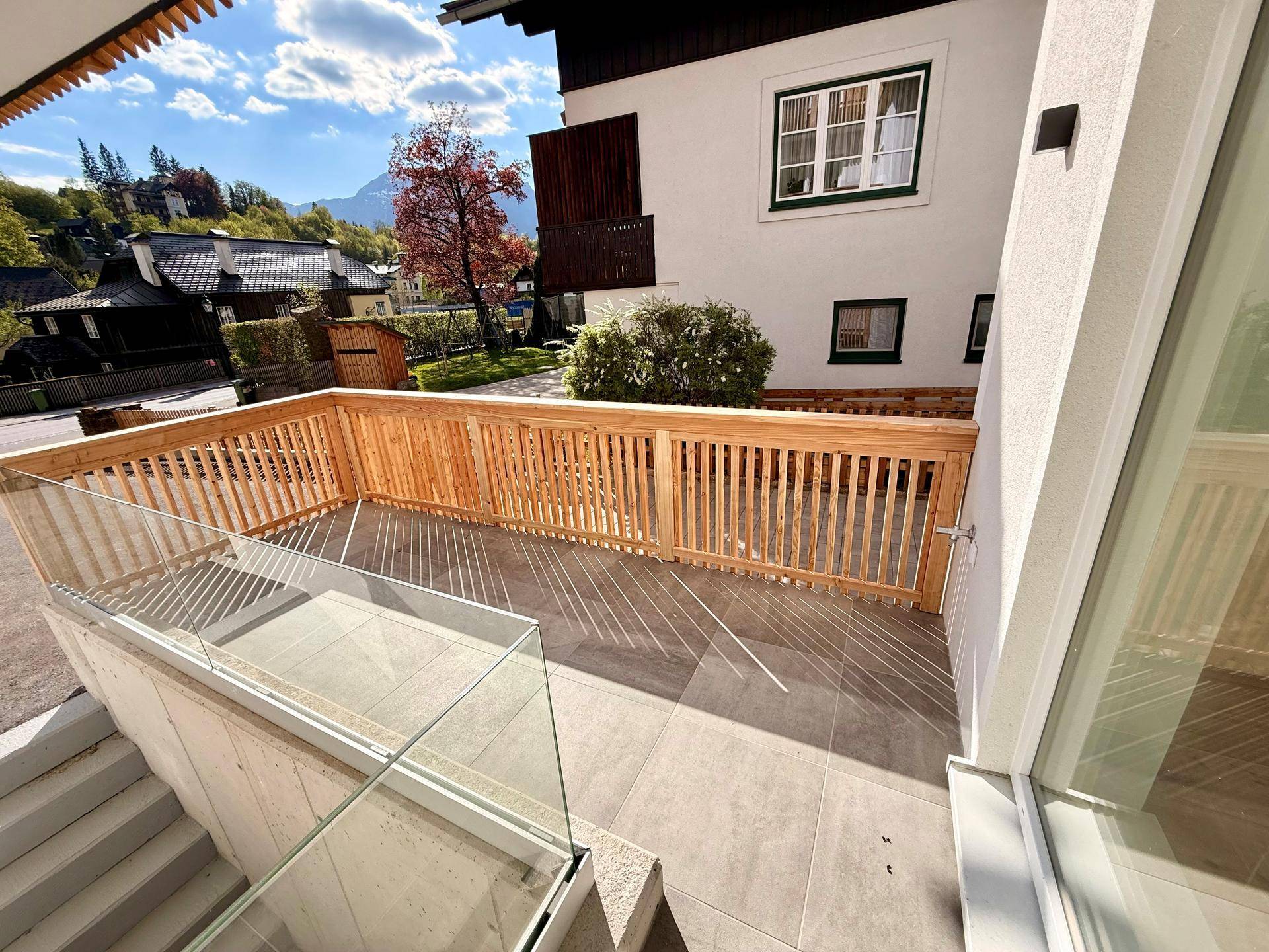 Geräumige Terrasse mit Holzgeländer und Blick auf die umliegende Berglandschaft.