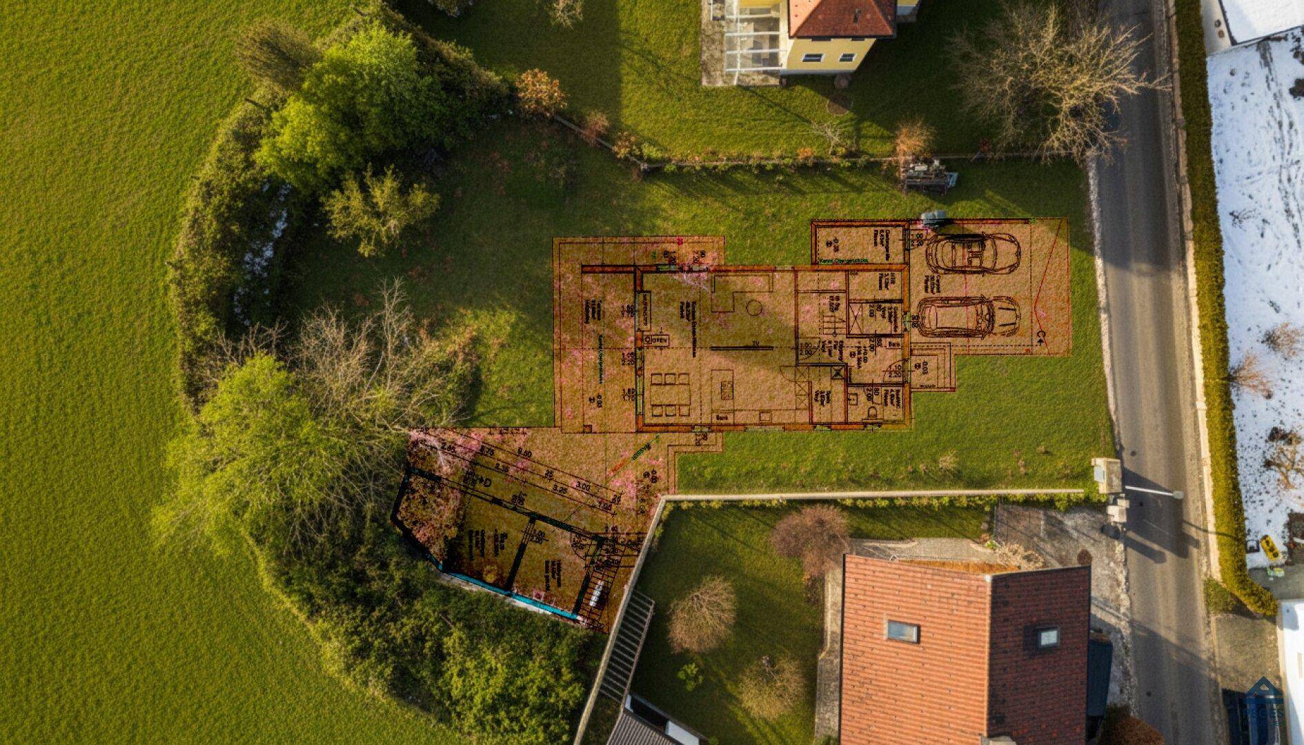 Grundriss eines Hauses über einem grünen Grundstück, zeigt die geplante Raumaufteilung und Garage.