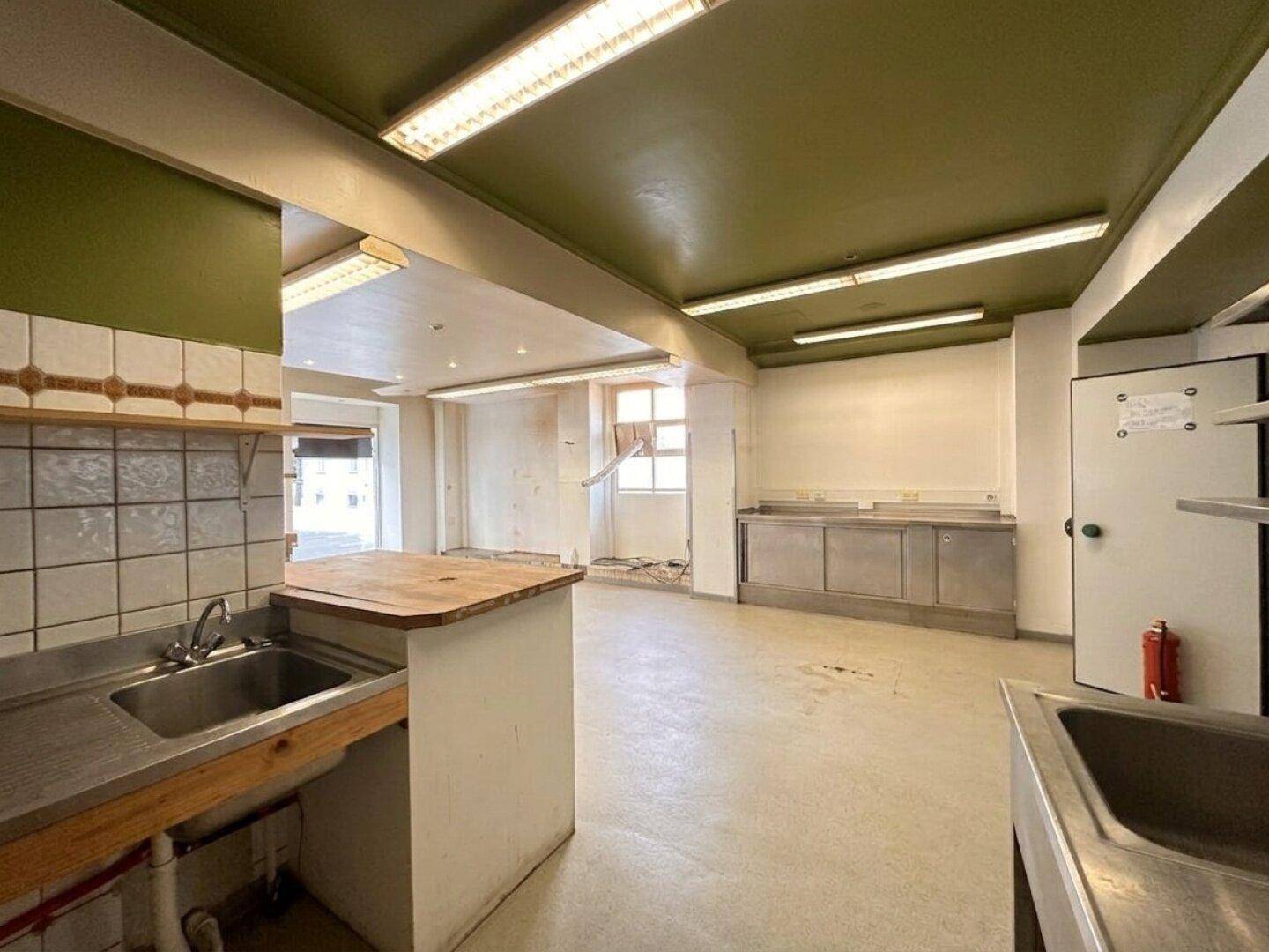 Gewerbliche Küche mit Edelstahlspülen und Arbeitsflächen, bereit für den Einsatz in einem Restaurantbetrieb.