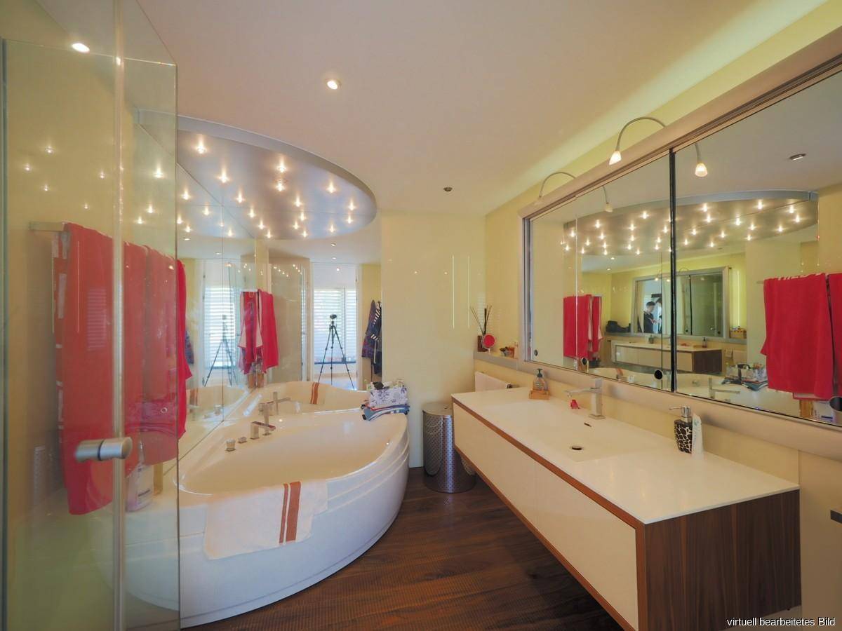 Modernes Badezimmer mit großer Badewanne, Doppelwaschbecken und Spiegelschrank.