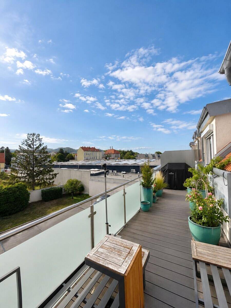 Lange Dachterrasse mit Holzboden, Pflanzen und Sitzgelegenheiten für entspannte Stunden.