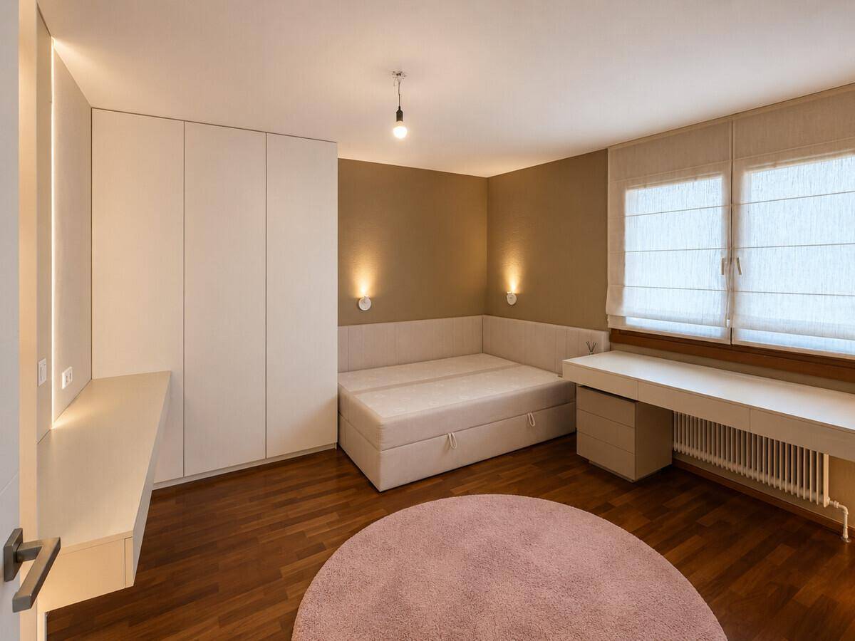 Modernes Schlafzimmer mit Holzboden, integrierten Schränken und einem bequemen Bett.